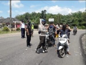 Kapolsek Mesuji OKI Bagikan Masker di Jalan Perbatasan